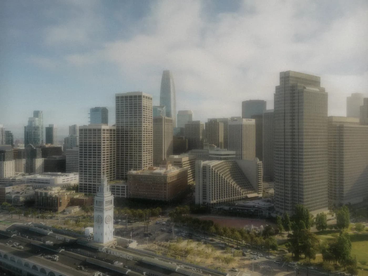 An aerial view of the San Francisco waterfront, the Ferry Building clock tower below the skyline